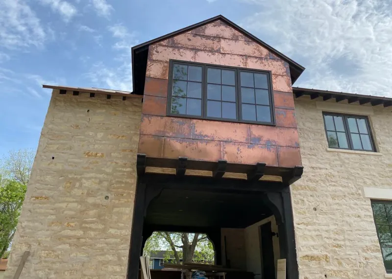Copper metal panel facade on a stone building for Skylight Installation in Bemidji